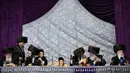 Orang-orang Yahudi ultra-ortodoks berbincang mendapat jamuan makanan saat menghadiri upacara pernikahan Hannah Halbershtam dan Menahem Nachum putra Rabi dari Dinasti Hasvor Nadvorna di kota ultra-ortodoks Bnei Brak, Israel, Selasa (20/8/2019. (AP Photo/Oded Balilty)