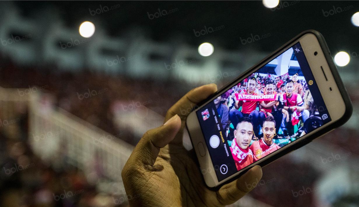 Suporter Timnas Indonesia selfie saat menonton laga semifinal Piala AFF 2016 melawan Vietnam di Stadion Pakansari, Jawa Barat, Sabtu (3/12/2016). (Bola.com/Vitalis Yogi Trisna)