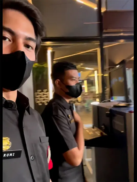 Dalam video singkat tersebut memperlihatkan Rumi sedang bertugas di pintu masuk. Bertugas di metal detector pemeriksaan tas. Sama dengan seorang pria yang berdiri disebelahkan, Rumi juga memegang dada saat menyapa pengunjung. [Instagram/elelrumi]