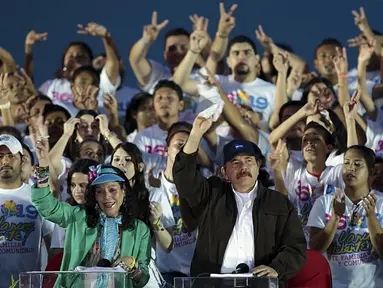 Presiden Nikaragua, Daniel Ortega bersama istrinya menyapa pendukungnya saat perayaan ke-36 Revolusi Sandinista di Managua, Nikaragua, Minggu, (19/7/2015). Daniel Ortega merupakan bagian revolusi Sandinista pada 1979 lalu. (REUTERS/Oswaldo Rivas)