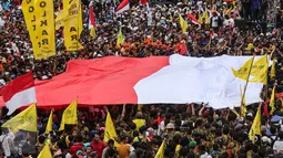 Bendera Merah Putih raksasa dibentangkan oleh para peserta parade 'Aksi Kita Indonesia' di Bundaran HI, Jakarta, Minggu (4/12). Nyanyian berbagai lagu nasional pun berkumandang saat para peserta parade memutari Bundaran HI. (Liputan6.com/Fery Pradolo)
