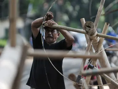 Pedagang mengikat bambu di bagian pohon pinang yang akan digunakan untuk perlombaan 17 Agustus nanti, Jakarta, Selasa (9/8). Jelang HUT RI ke-71, pedagang pohon pinang mulai ramai. (Liputan6.com/Yoppy Renato)