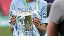 Gelandang Manchester City, Riyad Mahrez berpose dengan trofi saat merayakan kemenangan atas Tottenham Hotspur pada pertandingan final Piala Liga Inggris di stadion Wembley di London, Senin (26/4/2021). (AP Photo/Alastair Grant)