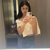 Tampil kekinian, kombinasi tank top dengan cardigan yang diikat sebagai luaran dan celana jeans bikin look makin stylish. [@shafeeamd_/@elelrumi].