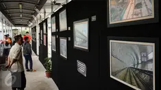 Warga melihat pameran foto kemajuan pembangunan MRT di Jembatan Penyebrangan Orang Bundaran Hotel Indonesia, Jakarta, Minggu (7/5). Pameran bertema Aku, Kamu, Kita #UbahJakarta. (Liputan6.com/Helmi Fithriansyah)
