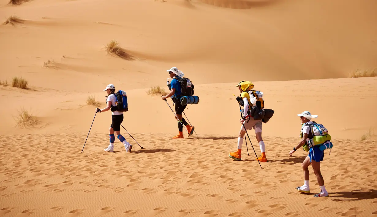 Para Peserta mendaki gurun Sahara saat mengambil bagian dalam kejuaraan marathon des Sables di Maroko Selatan, (10/4). Peserta akan menempuh jarak sekitar 257 kilometer melintasi panasnya gurun Sahara. (AFP PHOTO/JEAN-PHILIPPE Ksiazek)