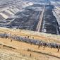 Aktivis iklim berjalan mamasuki tambang batu bara lignit Garzweiler di Garzweiler, Jerman barat, Sabtu (22/6/2019). Ratusan aktivis iklim menduduki tambang batu bara yang dijalankan oleh raksasa energi RWE. (Marcel Kusch/DPA/AFP)