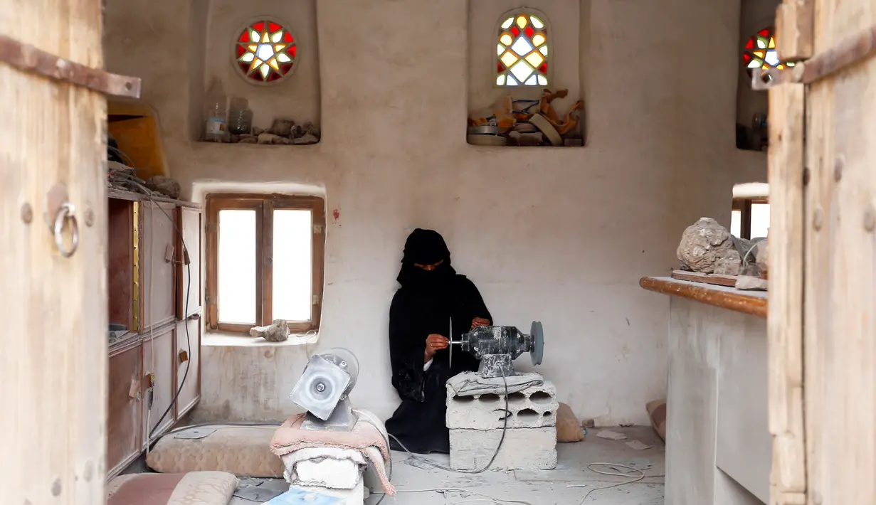 Seorang wanita bernama Safa al-Faqih menyelesaikan pembuatan batu mulia di tempat kerajinan di Sanaa, Yaman (18/4). (AFP/Mohammed Huwais)