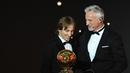 Gelandang Real Madrid asal Kroasia, Luka Modric, bersama legenda David Ginola saat malam penghargaan Ballon d'Or di Paris, Senin (3/12). Dirinya berhasil meraih gelar Ballon d'Or. (AFP/Franck Fife)