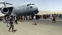 Ratusan orang berlari di samping pesawat angkut C-17 Angkatan Udara AS di landasan bandara internasional, di Kabul, Afghanistan (16/8/2021).  Ratusan warga Afghanistan berusaha kabur dari negaranya. Hal ini terjadi usai pemberontak Taliban menduduki ibu kota Afghanistan. (Verified UGC via AP)