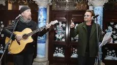 The Edge dan Bono U2 saat mengambil bagian dalam acara Malam Natal di Grafton Street, Dublin (24/12). (AP Photo/Lorraine O'Sullivan)
