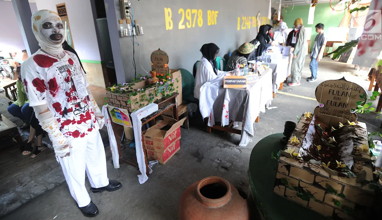 Anggota Kelompok Penyelenggara Pemungutan Suara (KPPS) Lebak Bulus melayani warga di TPS 073 yang bernuansa horor di Lebak Bulus, Jakarta Selatan, Rabu (17/4). TPS 073 ini mengambil tema horor untuk menarik minat masyarakat untuk mencoblos. (merdeka.com/Arie Basuki)