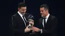 Penjaga gawang Argentina dan Aston Villa Emiliano Martinez (kiri) menerima penghargaan Kiper Pria Terbaik FIFA dari mantan pesepak bola Brasil Julio Cesar dalam penganugerahan The Best FIFA Football Awards 2022 di Paris, Prancis, Senin (27/2/2023). Sejak diadakan pada 2017, peraih penghargaan Kiper Terbaik Pria FIFA selalu berganti. (FRANCK FIFE / AFP)