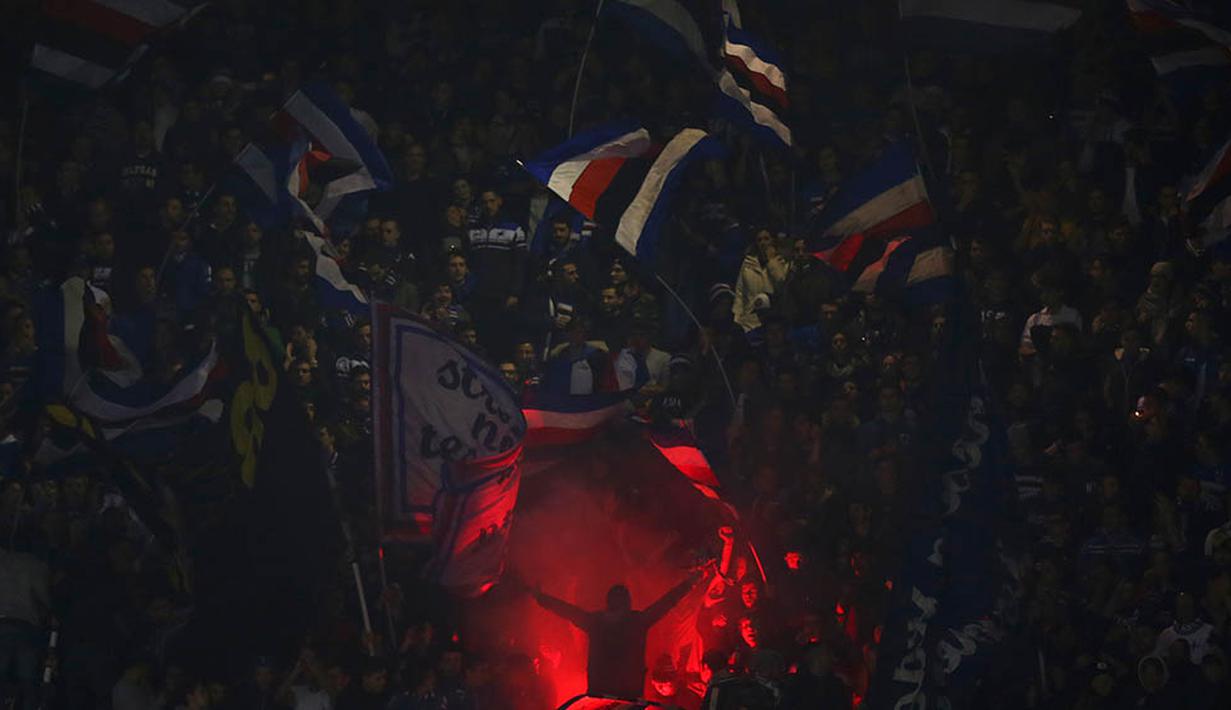 Supporter Sampdoria menyalakan suar saat laga Serie A melawan Juventus di Stadion Luigi Ferraris, Italia, Minggu (10/1/2016). Juventus berhasil menang 2-1. (AFP/Marco Bertorello)