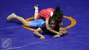 Pegulat putri Kaltim, Inadrah (kostum merah) mengunci gerakan pegulat Sumbar Mardiatul saat final gaya bebas kelas 53 kg putri pada PON XIX di Arena Saparua Sport Park, Bandung, Sabtu (24/9). Inadrah berhasil raih emas. (Liputan6.com/Helmi Fithriansyah)
