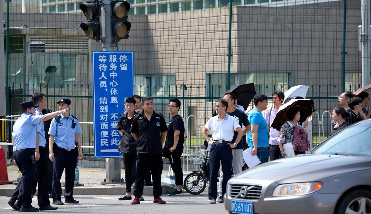 Personel keamanan China berdiri di luar kedutaan besar Amerika Serikat setelah laporan ledakan di Beijing, Kamis (26/7). Ledakan disebut berada dekat tempat warga China mengantre untuk masuk ke Kedubes AS untuk mengurus visa. (AP/Mark Schiefelbein)