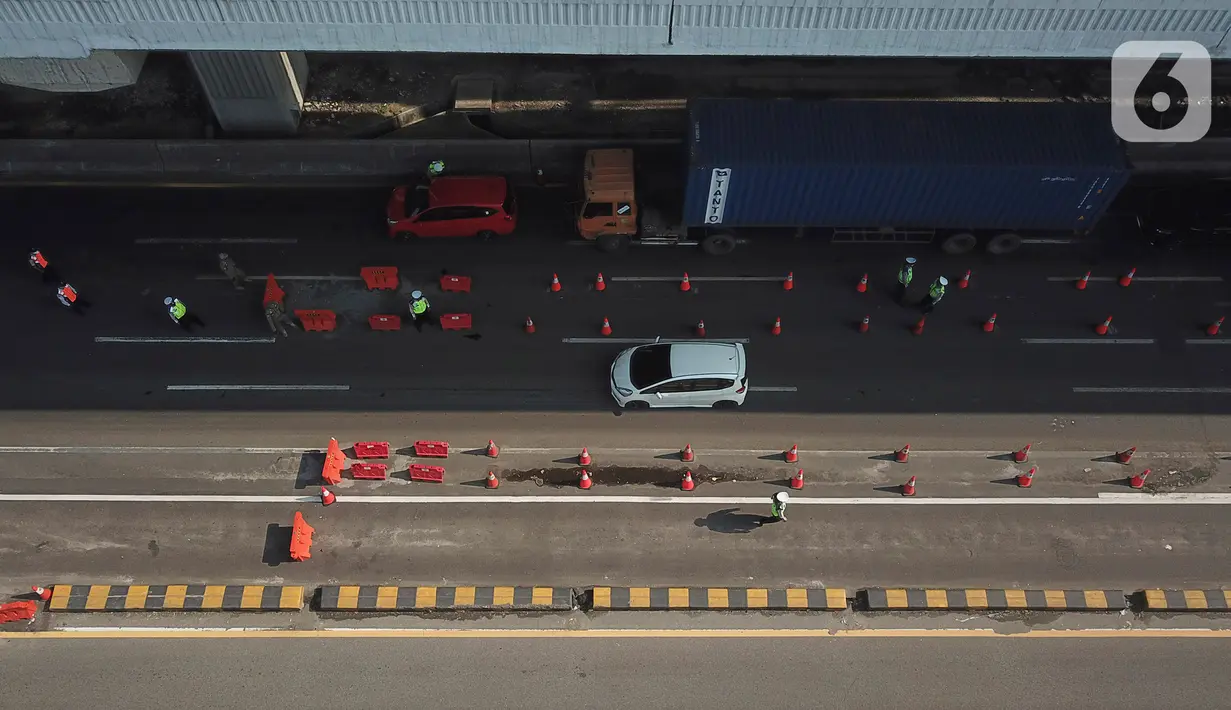 Foto udara suasana  pos penyekatan pemudik Tol Cikarang Barat, Kabupaten Bekasi, Jawa Barat, Minggu (9/5/2021). Petugas gabungan memperketat pemeriksaan dokumen kendaraan yang melintasi pos penyekatan pemudik jelang H-3 perayaan Hari Raya Idul Fitri 1442 H. (Liputan6.com/Herman Zakharia)