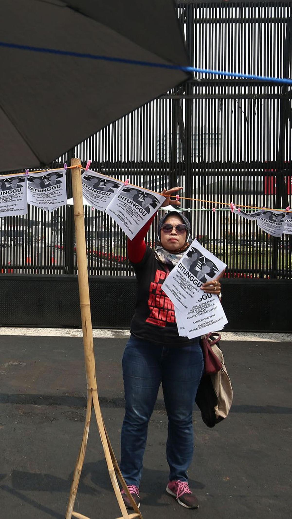 Dalam aksinya, massa PRT tampak memasang tali jemuran di depan Gedung DPR.