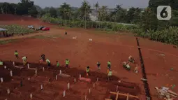 Foto udara memperlihatkan aktivitas pemakaman dengan protokol COVID-19 di TPU Pondok Ranggon, Jakarta, Sabtu (10/10/2020). Pemprov DKI Jakarta telah memperluas lahan TPU Pondok Ranggon sekitar 13.500 meter persegi untuk pemakaman jenazah dengan protokol COVID-19. (Liputan6.com/Helmi Fithriansyah)