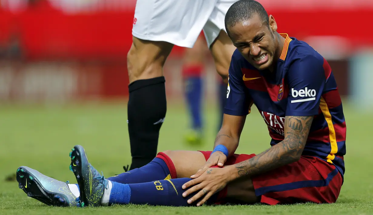 Neymar menahan sakit saat laga melawan Sevilla di lanjutan La Liga Spanyol, Minggu (4/10/2015). Tanpa Messi, Barcelona harus mengakui keunggulan Sevilla dengan skor akhir 2-1. (REUTERS/Marcelo del Pozo)