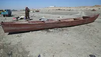 Nelayan berjalan di samping perahunya di tepi Danau Razzaza, juga dikenal sebagai Danau Milh, di provinsi Karbala, Irak, 14 Februari 2022. Danau Razzaza Irak pernah menjadi objek wisata terkenal dengan pemandangan indahnya dan banyak ikan yang menjadi andalan penduduk setempat (AP Photo/Hadi Mizban)