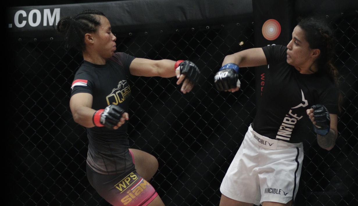 Petarung Indonesia, Priscilla Lumban Gaol, beradu pukulan dengan petarung India, Puja Tomar, saat bertarung pada laga ONE Championship di Istora Senayan, Jakarta, Sabtu (19/1). Priscilla kalah dari Puja. (Bola.com/M. Iqbal Ichsan)