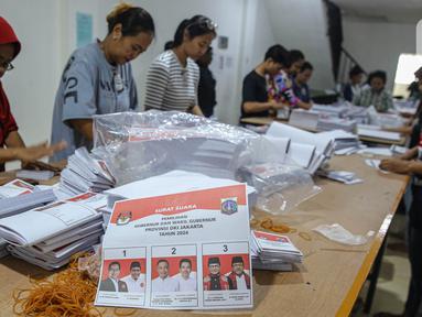 Pekerja menyortir dan melipat surat suara Pilkada DKI Jakarta 2024 di Gudang Logistik Komisi Pemilihan Umum (KPU) Jakarta Pusat, Rabu  (23/10/2024). (Liputan6.com/Angga Yuniar)