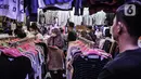 Pedagang mengamati pengunjung memilih pakaian bekas impor di Pasar Senen, Jakarta, Kamis (4/3/2021). Rudi (34) salah satu pedagang mengungkapkan penjualan pakaian bekas impor di Pasar Senen merosot hingga 50 persen sejak awal pandemi COVID-19 melanda Ibu Kota. (merdeka.com/Iqbal S. Nugroho)