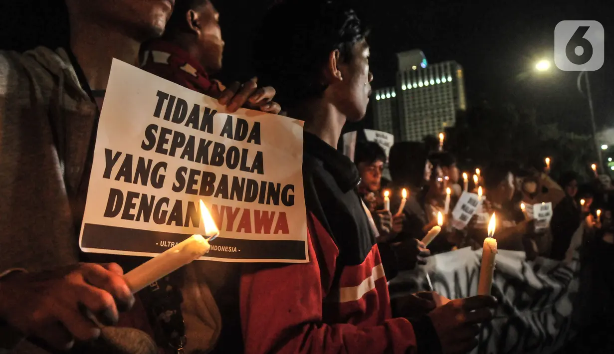 Massa yang tergabung dalam Ultras Garuda Jakarta menggelar aksi seribu lilin dan tabur bunga untuk korban kerusuhan Stadion Kanjuruhan Malang di depan Stadion Gelora Bung Karno (GBK), Jakarta, Minggu (2/10/2022). Aksi yang diikuti ratusan pecinta sepakbola di Jakarta tersebut sebagai bentuk belasungkawa terhadap ratusan korban yang tewas dalam kerusuhan di Stadion Kanjuruhan Malang kemarin. (merdeka.com/Iqbal S Nugroho)