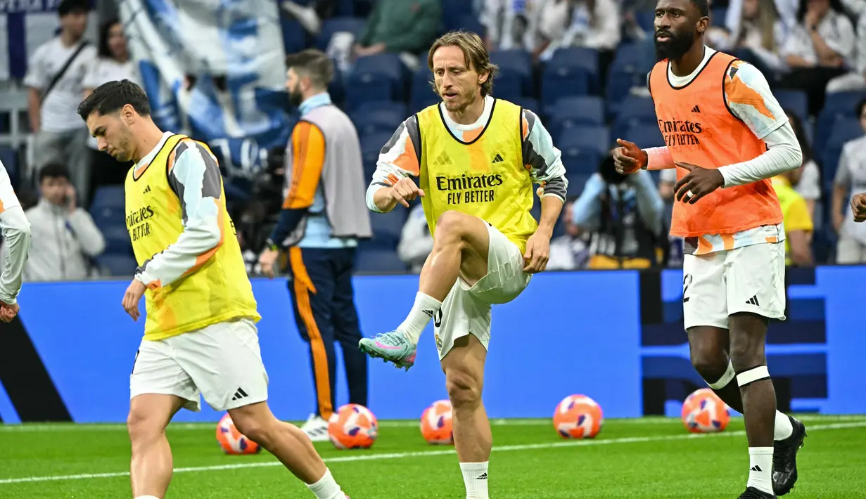 Bergabung pada 2012, Luka Modric menjadi bagian penting dari masa keemasan Real Madrid. Tampak dalam foto, gelandang Real Madrid asal Kroasia, Luka Modric (tengah) melakukan pemanasan sebelum pertandingan sepak bola Liga Spanyol melawan Valencia CF di stadion Santiago Bernabeu, Madrid, 5 April 2025. (JAVIER SORIANO/AFP)