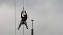 Pengunjung meluncur dengan seutas tali saat melakukan permainan Zip Line dari lantai dua Menara Eiffel di atas taman Champ de Mars, Paris, Selasa (28/5/2019). Permainan ini akan membiarkan pengunjung terbang di atas kerumunan turis di Champs de Mars sebelum mendarat dengan selamat (AP/Francois Mori)