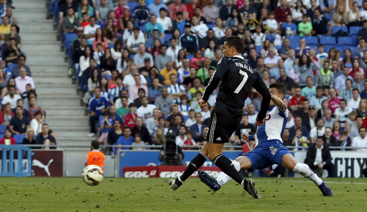Penyerang Real Madrid, Cristiano Ronaldo berusaha menendang bola dari kejaran pemain Espanyol pada laga Liga Spanyol di Stadion Power8, Senin (18/5/2015). Real Madrid menang 4-1 atas Espanyol. (Reuters/Gustau Nacarino)