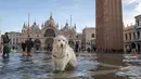 Cannella (Cinnamon), seekor golden retriever muda melihat ke kamera saat berhenti di St Mark's Square yang dibanjiri oleh air laut, di Venesia, Italia, Sabtu (4/12/2021). Air mencapai 99 sentimeter di atas permukaan laut dan bagian terendah kota tenggelam. (AP Photo/Luigi Costantini)