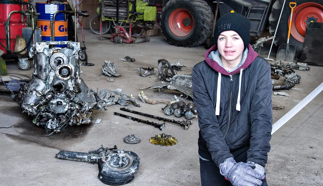 Bocah berusia 14 tahun, Daniel Kristensen bersama ayahnya menemukan puing pesawat Perang Dunia II, Denmark, Selasa (7/3). Daniel menemukan puing pesawat tersebut saat menyusuri rawa dengan traktor.(AFP Photo/ HENNING BAGGER)