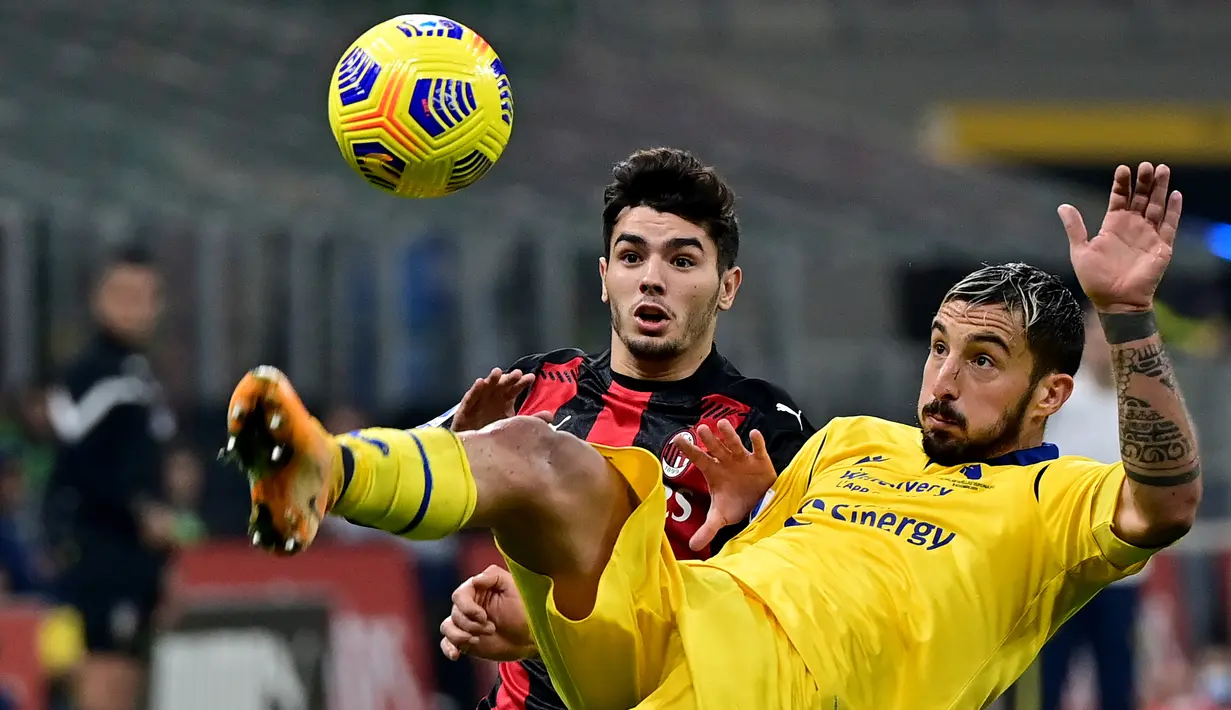Penyerang AC Milan, Brahim Diaz (kiri) berebut bola dengan bek Hellas Verona, Federico Ceccherini pada lanjutan Liga Italia Serie A di San Siro, Senin (9/11/2020) dinihari WIB. AC Milan harus puas berbagi angka dengan Hellas Verona setelah bermain imbang 2-2. (Miguel MEDINA / AFP)