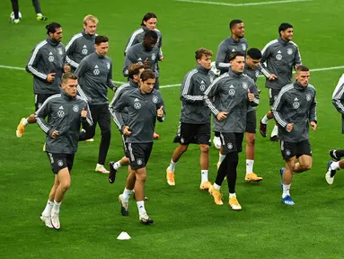 Para pemain timnas Jerman melakukan pemanasan saat sesi latihan di stadion Rheinenergie di Cologne, Jerman barat (9/10/2020). Jerman akan bertanding melawan Turki pada laga persahabatan di stadion Rheinenergie di Cologne, Jerman, Kamis (8/10/2020). (AFP/Ina Fassbender)