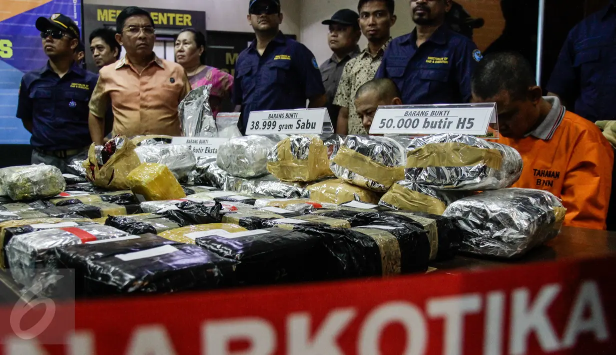 Barang bukti dan tersangka diperlihatkan saat rilis sindikat peredaran narkotika jaringan Malaysia di Gedung BNN, Jakarta, Jumat (28/10). Sebanyak 50.000 butir H5, 39 kg sabu dan 98.960 butir ekstasi berhasil diamankan petugas. (Liputan6.com/Yoppy Renato)