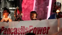 Massa aksi yang tergabung dalam Pencinta NKRI dan Pancasila menggelar doa bersama untuk Papua di Tugu Proklamasi, Menteng, Jakarta, Selasa (20/8/2019).  Aksi dengan menyalakan lilin sebagai bentuk solidaritas untuk perdamaian di Tanah Papua. (Liputan6.com/Faizal Fanani)