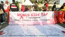 Sebuah spanduk petisi Peduli HIV/AIDS dibentangkan di kawasan Bundaran HI saat Car Free Day, Jakarta, Minggu (13/12/2015). Kegiatan tersebut dalam rangka memperingati hari AIDS sedunia. (Liputan6.com/Yoppy Renato)