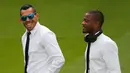 Penyerang Juventus, Carlos Tevez bersama Bek Patrice Evra berbincang jelang persiapan konferensi pers di Stadion Santiago Bernabeu, Spanyol (12/5/2015). Juventus akan menantang Real Madrid di leg kedua semifinal Liga Champions.  (Reuters/Sergio Perez)