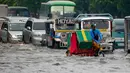 Pengendara becak menerjang genangan air di salah satu wilayah Manila, Filipina, Kamis (27/7). Banjir menggenangi beberapa wilayah Kota Metropolitan setelah hujan lebat yang diakibatkan oleh badai tropis ‘Nesat’. (AP/Bullit Marquez)
