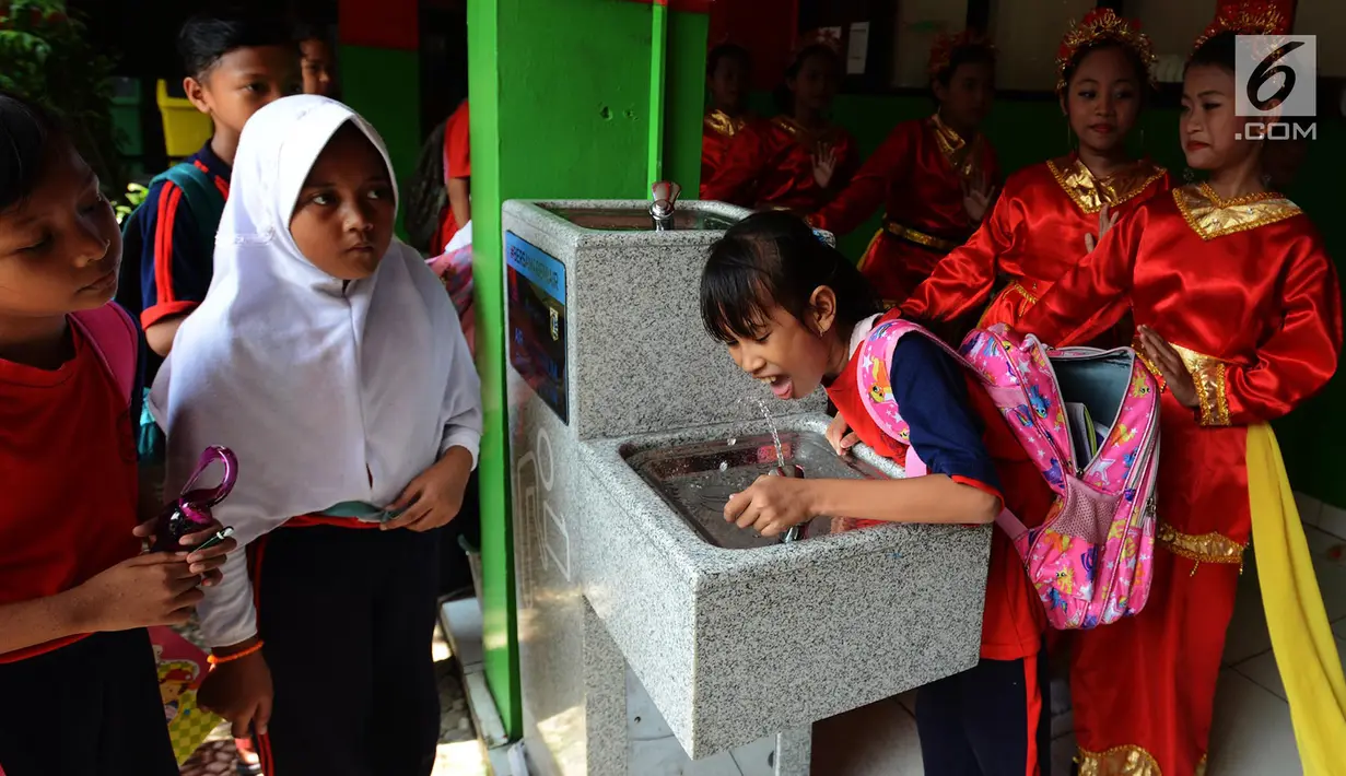Siswa meminum air bersih langsung dari keran di SDN 03 dan SDN 04 Penjaringan, Jakarta, Jumat (22/3). Kegiatan ini bertujuan menyediakan air siap minum yang higenis dan bersih bagi siswa serta guru. (merdeka.com/Imam Buhori)