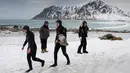 Sejumlah peselancar usai berselancar di pantai bersalju Flackstad di Kepulauan Lofoten, Lingkar Arktik, pada 13 Maret 2016. Suhu dingin memberikan sensasi tersendiri bagi peselancar terlepas dari cuaca yang sangat tidak stabil. (AFP/Olivier Morin)