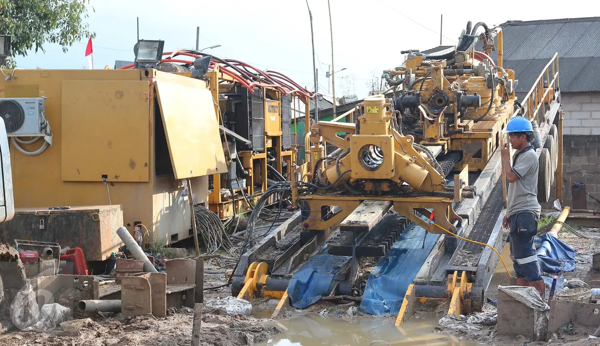 Pekerja mengontrol pengerjaan penanaman pipa gas open access di Desa Segaramakmur, Tarumajaya, Kabupaten Bekasi, Senin (8/8).Penanaman pipa kedalam tanah menggunakan teknologi pengeboran horizontal secara langsung (HDD). (Liputan6.com/Angga Yuniar)