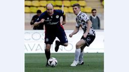 Pangeran Albert II berusaha melewati Max Verstappen dalam laga amal di Stade Louis II Monako, Selasa (24/5/2016). (AFP/Jean Christophe Magnenet)