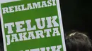 Seorang Nelayan membawa tulisan 'TELUK JAKARTA UNTUK SIAPA' saat demo menolak reklamasi teluk Jakarta di depan kantor DPRD DKI Jakarta, Selasa (1/3). (Liputan6.com/Gempur M Surya)