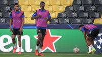 Bek Manchester United Prancis Raphael Varane (kiri), gelandang Paul Pogba (kedua dari kiri) dan Jesse Lingard ambil bagian dalam sesi latihan di Bern (13/9/2021). Manchester United akan bertanding melawan Young Boys pada Grup F Liga Champions di Stadion Wankdorf. (AFP/Sebastien Bozon)