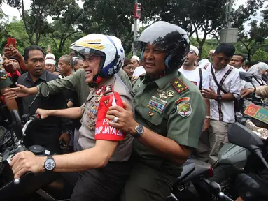 Kapolda Metro Jaya Irjen Pol Mochammad Iriawan bersama Mayor Jenderal TNI Teddy Lhaksmana mengendarai motor trail saat melintasi pengunjuk rasa di depan gedung Balaikota DKI Jakarta, Jumat (14/10). (Liputan6.com/Immanuel Antonius)