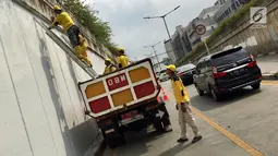 Suasana saat Pasukan Kuning mengecat dinding Underpass Kebayoran Baru, Jakarta Selatan, Kamis (1/2). Pengecatan dilakukan agar dinding underpass tidak kusam serta menghindari kesan kumuh. (Liputan6.com/Immanuel Antonius)