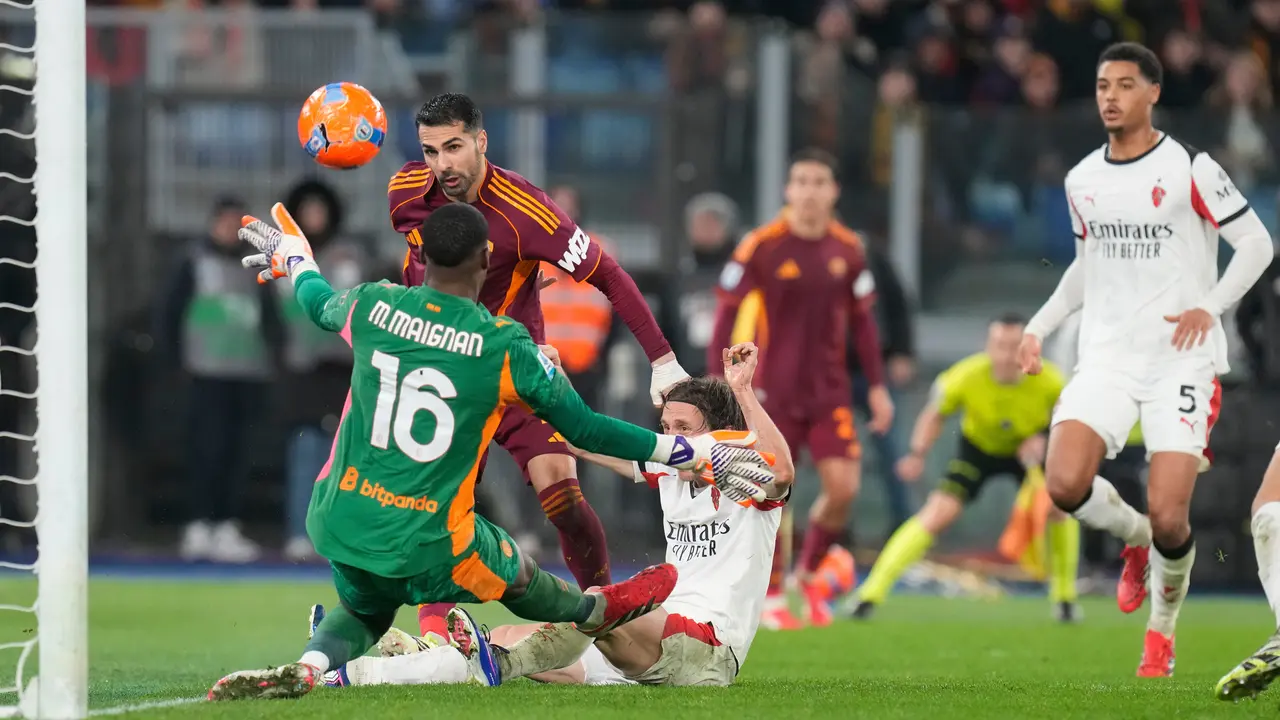 Mike Maignan berusaha menghalau usaha Zeki Celik mengancam gawangnya di laga AS Roma vs AC Milan di pekan ke-22 Liga Italia 2025/2026 di Olimpico, Senin (26/01/2026) dini hari WIB.